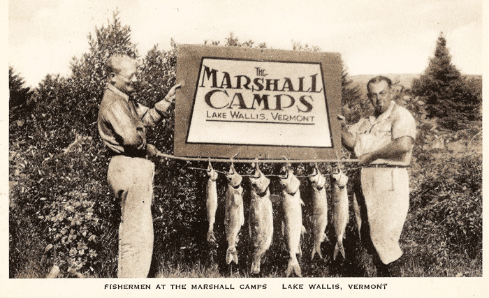 An old postcard showing two fisherman holding a string of freshly caught trout and a sign which reads: The Marshall Camps - Lake Wallis Vermont